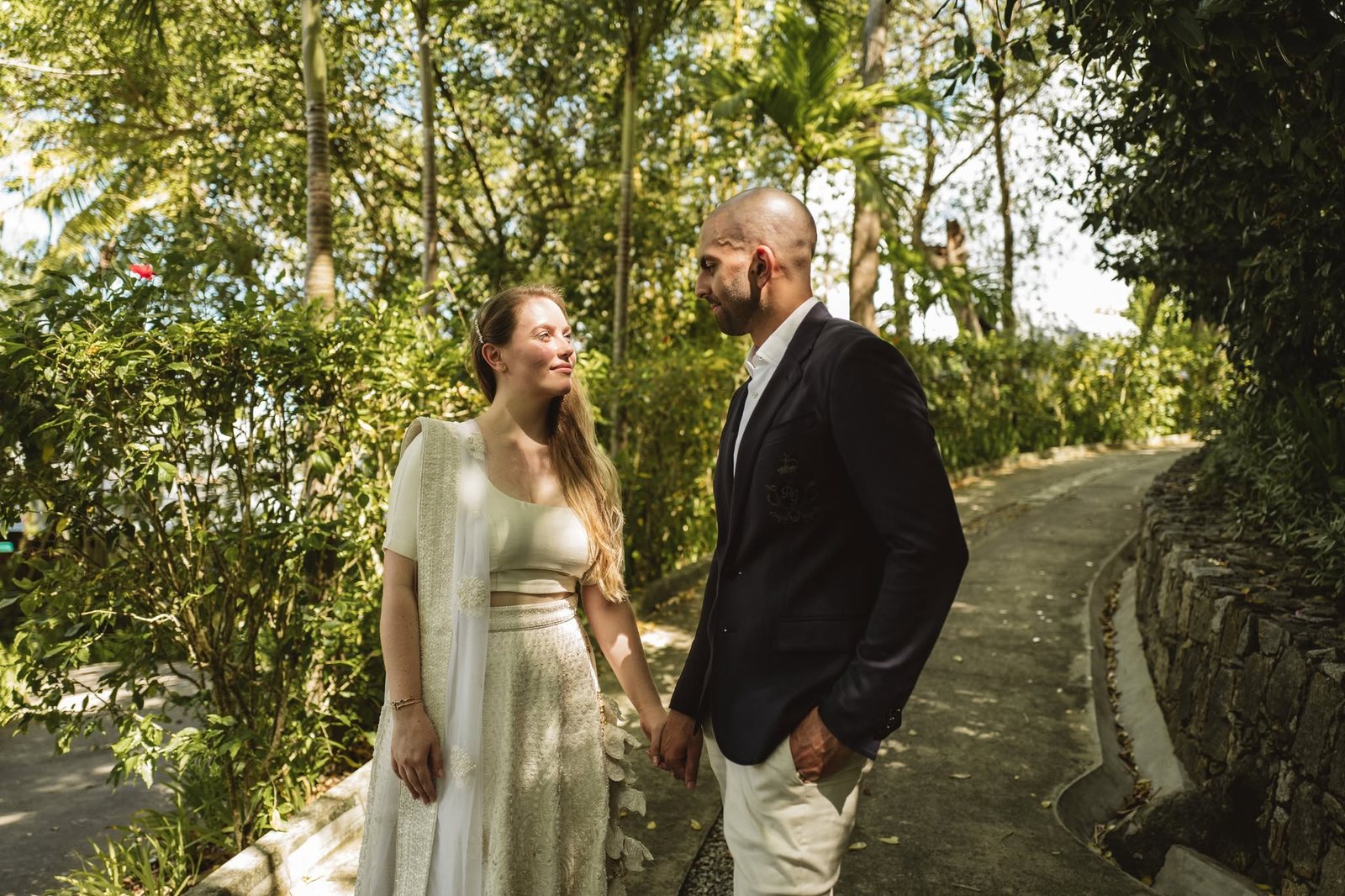 Bride and groom on a green garden path in dappled light