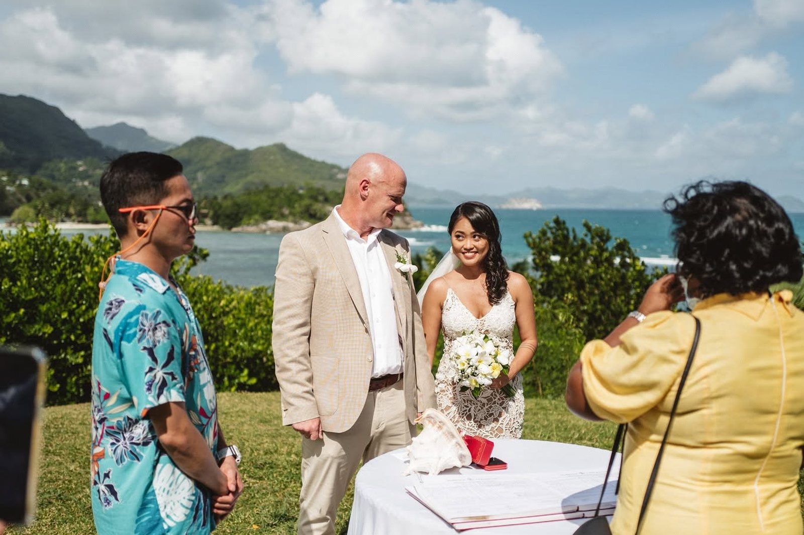 A registrar conducting the ceremony at a table on the grass