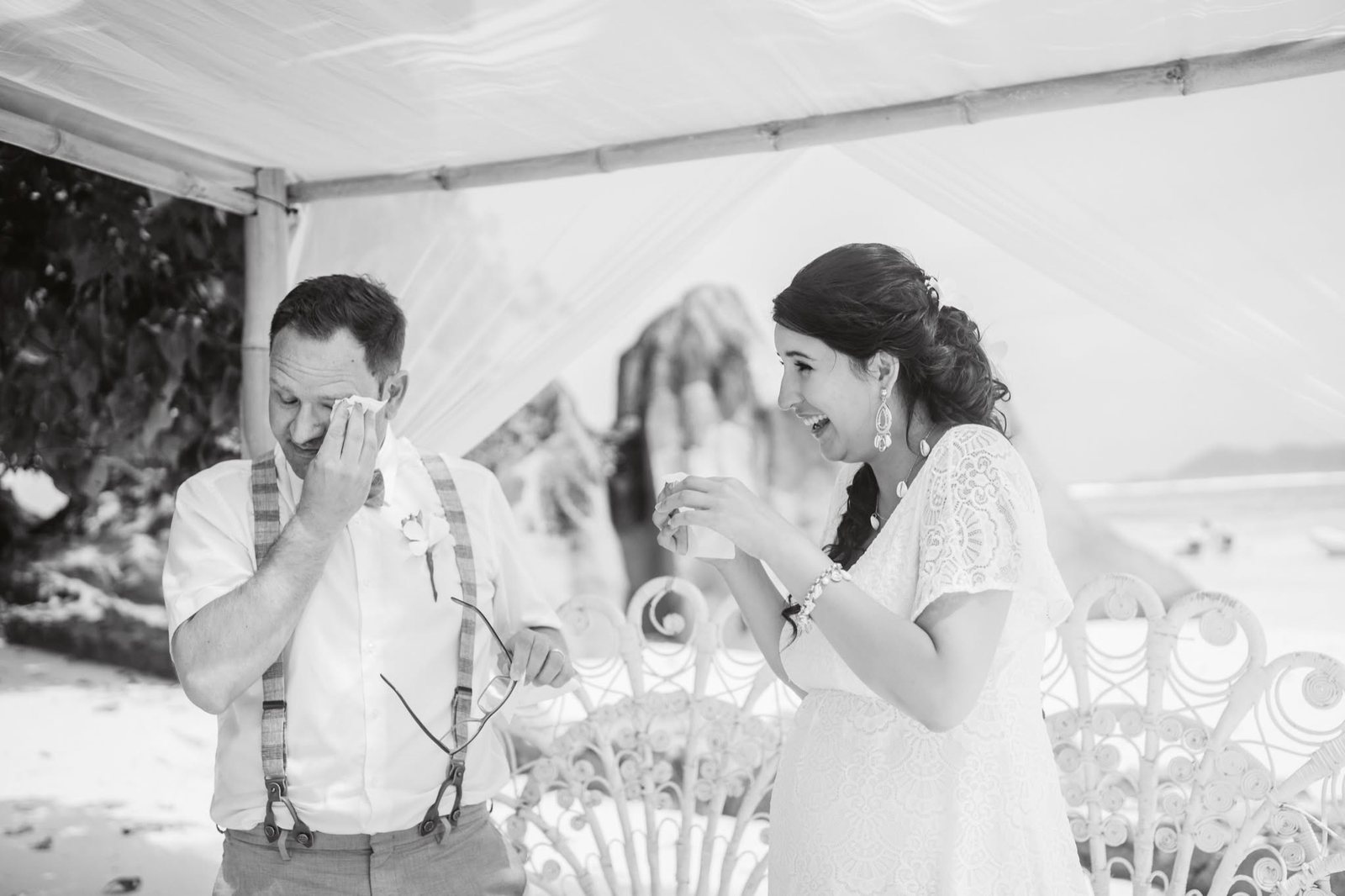 A groom in happy tears and a laughing bride after the vows at Grand Anse, La Digue