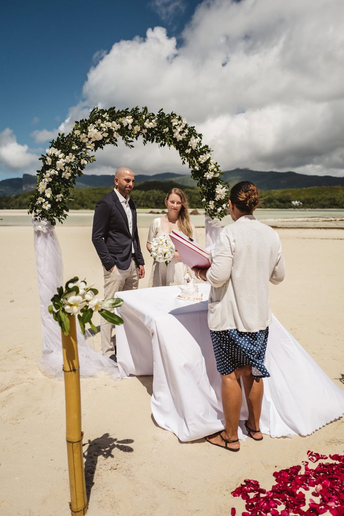 A couple under a flower arch on a private island near Mahe