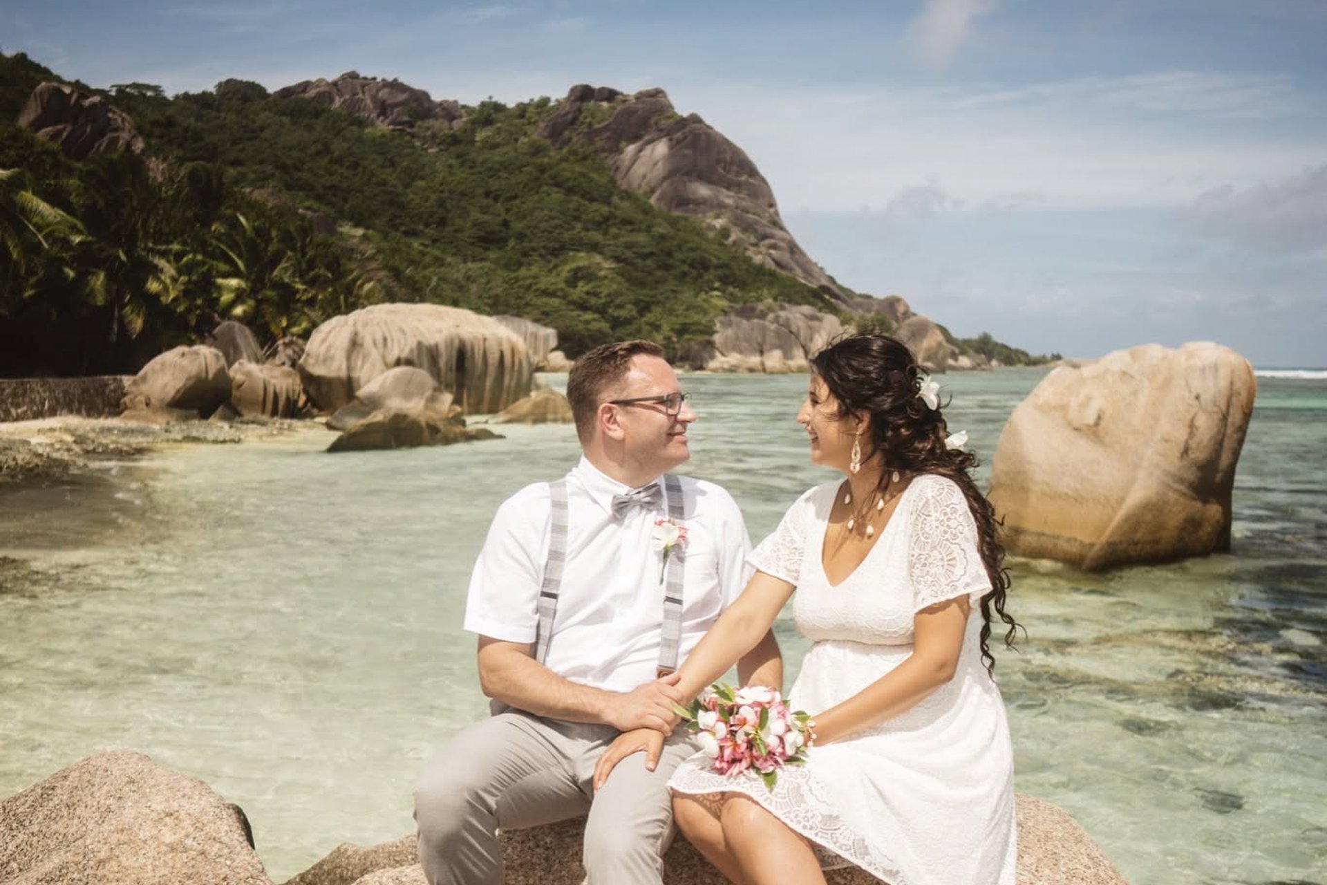 A couple resting on the rocks at Anse Source d'Argent, La Digue