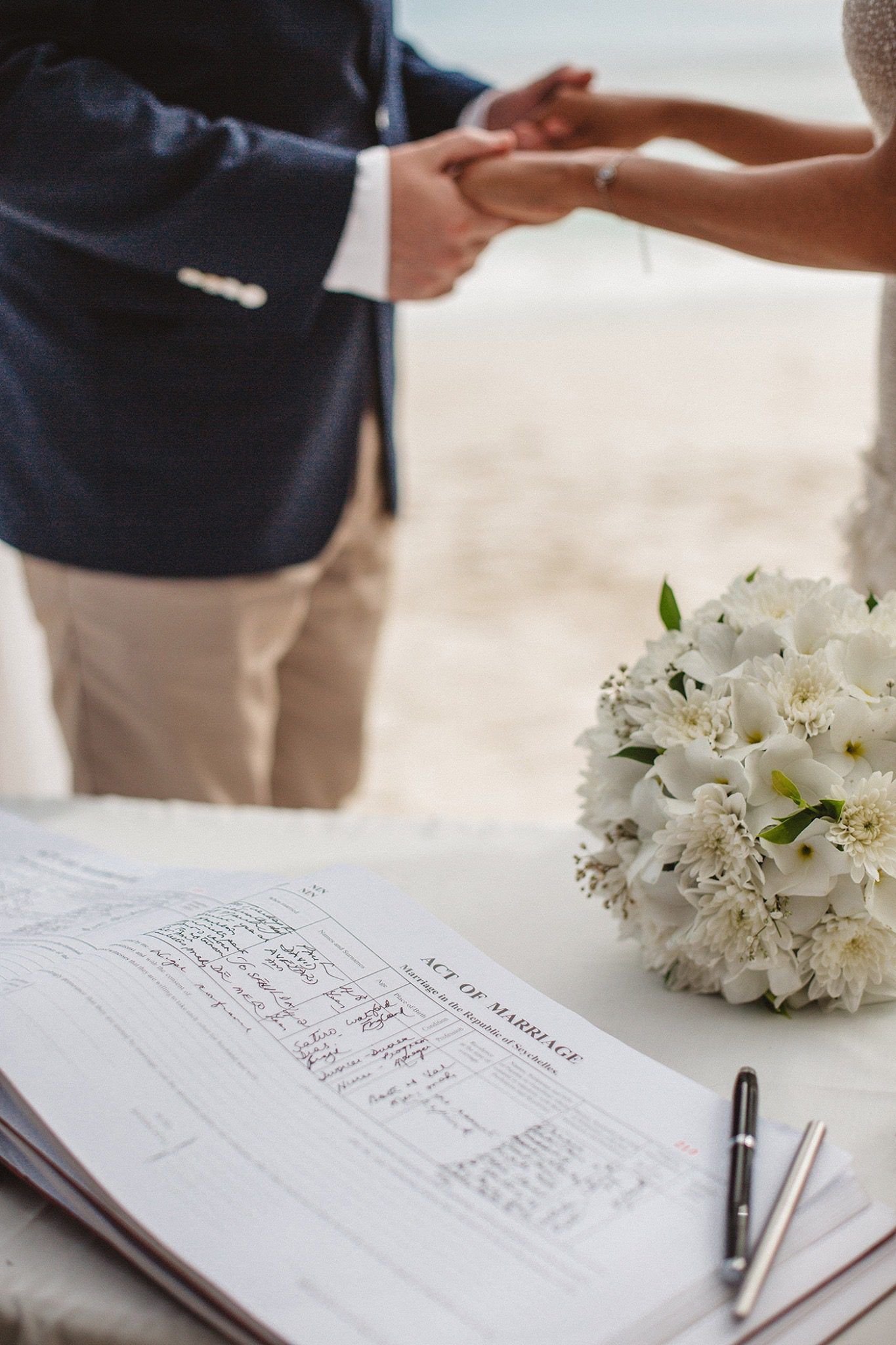 The Act of Marriage register open on the table beside a white bouquet
