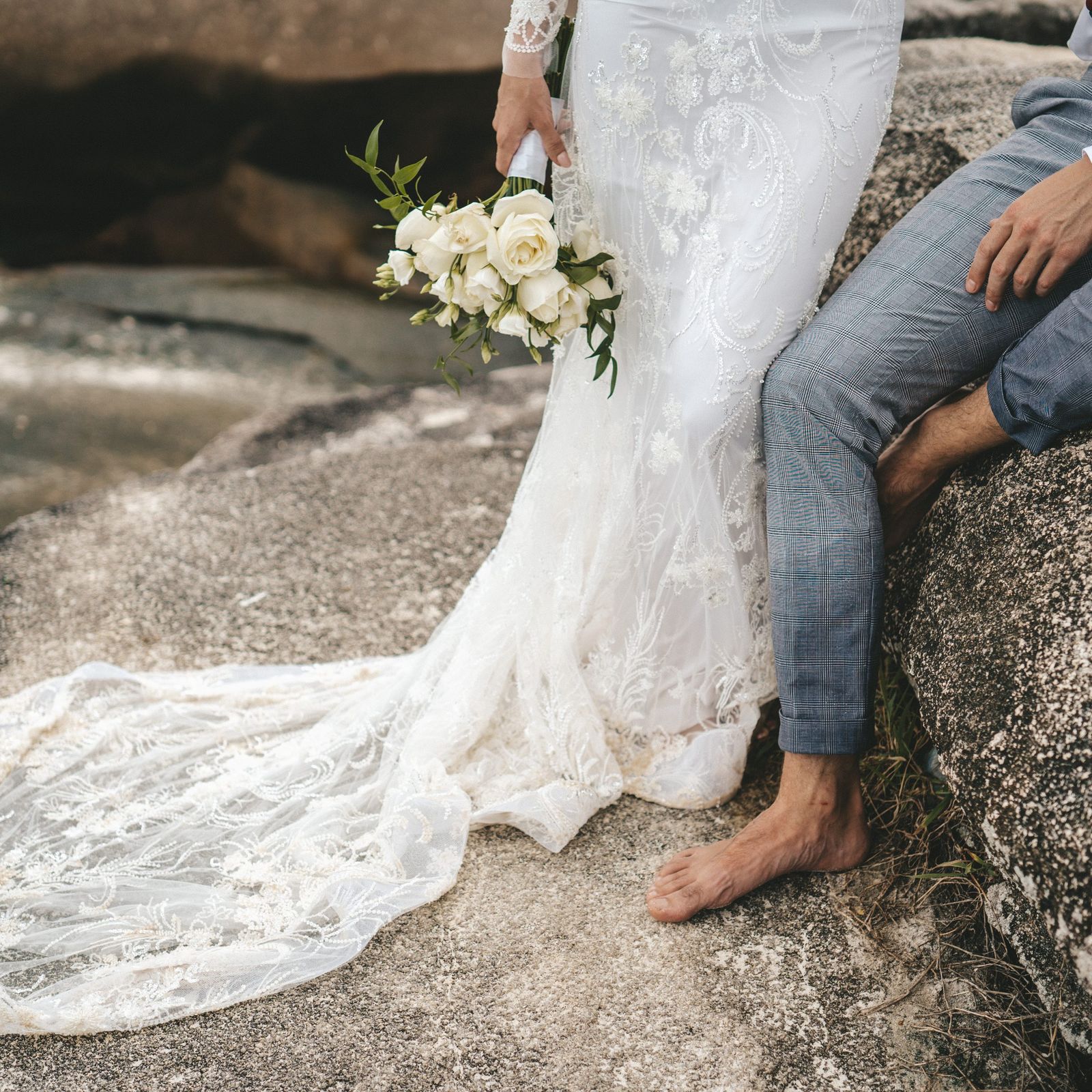 The lace train spread across warm granite beside his bare feet