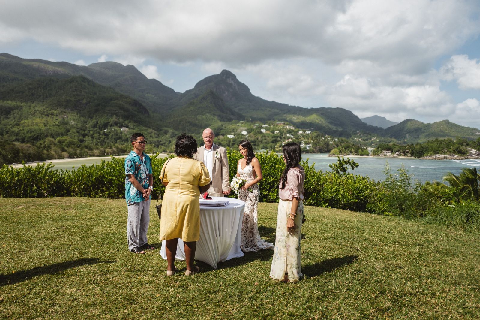 A hilltop ceremony circle above the bay, witnesses gathered