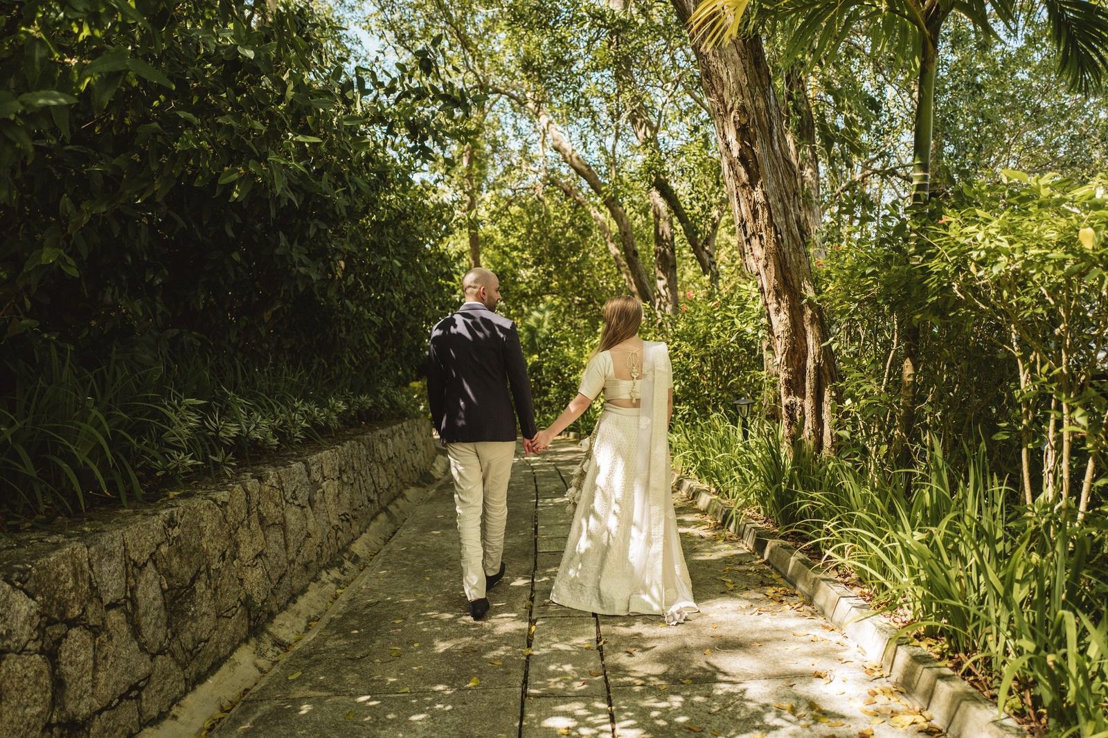 Walking a shaded garden path away from the camera