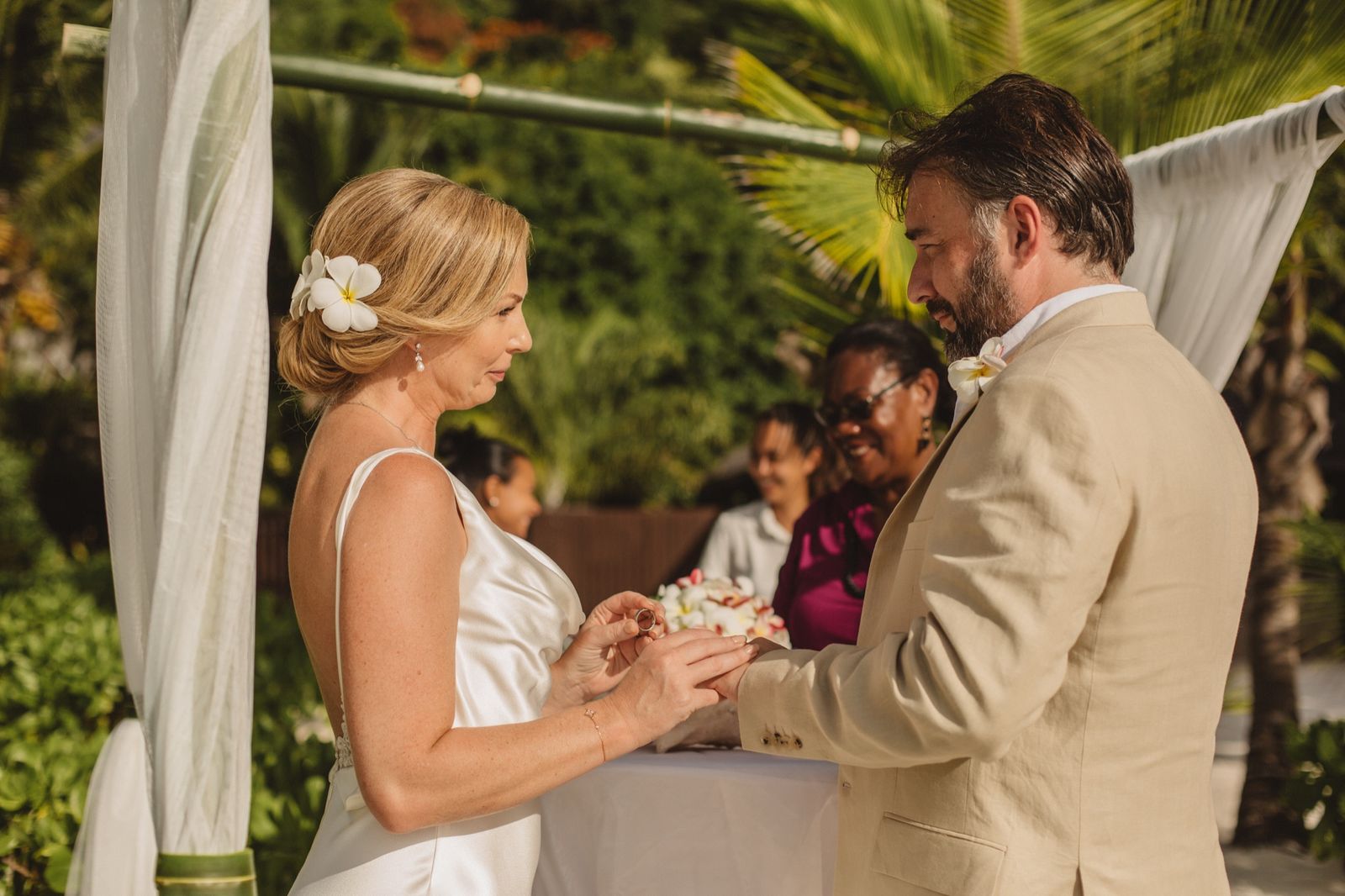 Ceremony table on the beach with tropical flowers at golden hour