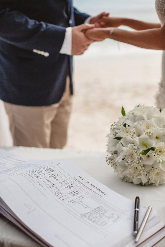 The Act of Marriage register open on the table beside a white bouquet