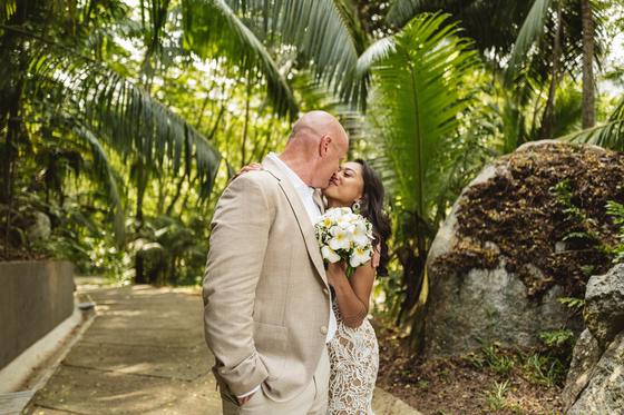 A kiss on a jungle path, bouquet of frangipani in her hand