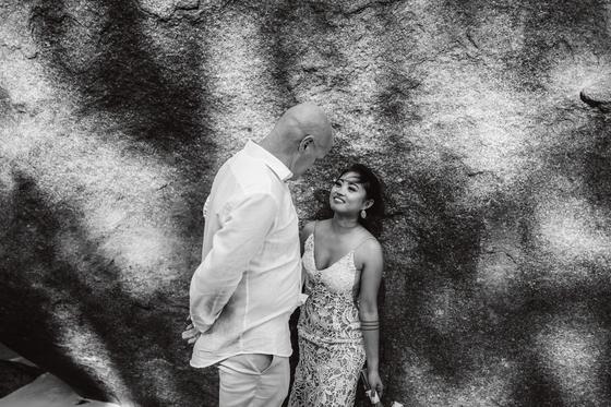 Leaning on a granite wall in dappled light, in black and white