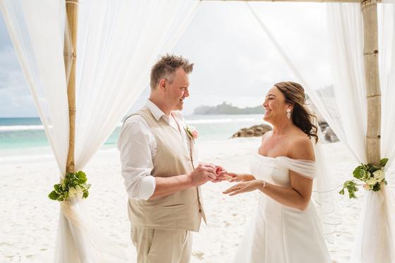 Bride and groom laughing during the ring exchange under the gazebo