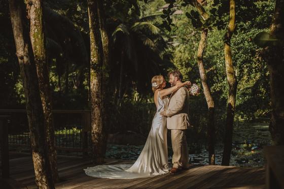A kiss on a wooden boardwalk over a lily pond