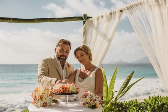Cutting the cake together under the white gazebo
